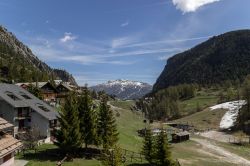 Veduta panoramica di Claviere in primavera con la neve sulle cime più alte, Piemonte. Sulla destra, uno scorcio della seggiovia.



