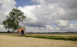 Veduta panoramica di un campo di grano con una chiesetta a Park Lingezegen, Nijmegen (Olanda). Il piccolo edificio religiosoè stato eretto in memoria dei soldati caduti nella Seconda ...