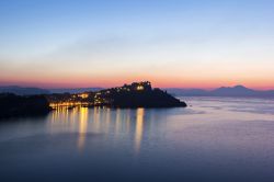 Veduta serale della Marina della Corricella a Procida con il  Vesuvio sullo sfondo, Campania. Siamo nel borgo marinaro più antico dell'isola, disposto ad anfiteatro sul mare: ...