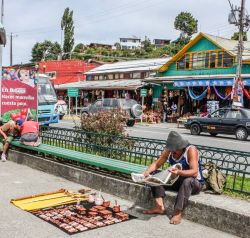 Un venditore di souvenir legge il giornale in attesa di clienti lungo una strada di Puerto Montt, Cile - © Natalia Ramirez Roman / Shutterstock.com