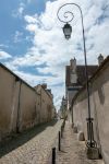 Un vicoletto acciottolato nel centro di Bourges, Francia, con un lampione in ferro battuto in primo piano - © Omaly Darcia / Shutterstock.com