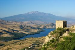 Vista da Agira con una vecchia torre, il lago di Pozzilla e il vulcano Etna sullo sfondo (Sicilia).
