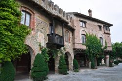 Scorcio panoramico su strada e portici di Grazzano Visconti, Piacenza - Case affrescate e impreziosite da edera e botteghe artigianali specializzate nella lavorazione del ferro battuto si possono ...