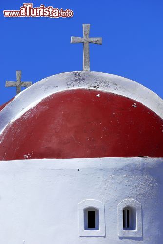 Immagine La piccola chiesa dell'isola di Kassos, Dodecaneso (Grecia) - Con quel tetto arrotondato, morbido, così liscio da sembrare un'opera di Gaudì deambulante o un progetto fatto da un bambino, non si può che pensare a quanto la Grecia sia riconoscibile guardandola in alto. Esempio altissimo in questo senso è dato dal piccolo complesso ecclesiastico di Kassos, le cui caratteristiche sono semplicissimi. Minimale, forse troppo, proprio questo ne determina la sua peculiarità e soprattutto, come si vede dall'immagine, quel rosso magenta che spicca in modo così vivace non può fare a meno di catturare l'attenzione di ogni visitatore - © Antlio / Shutterstock.com