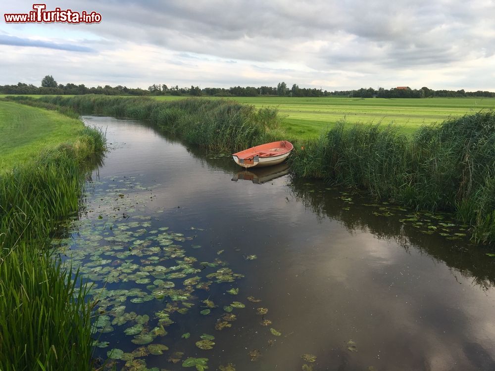 Immagine Un piccolo corso d'acqua con una barca ormeggiata sulle sponde vicino a Sneek, Frisia, Olanda.