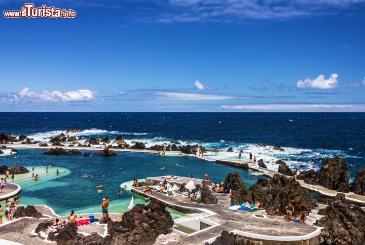 Immagine Le piscine naturali di Porto Moniz sulla costa di Madeira (Portogallo) - Porto Moniz, piccola località, nonostante le sue dimensioni contenute rispetto ad altre città delle zone limitrofe a Madeira, rappresenta comunque la meta più apprezzata dai turisti, soprattutto quelli estivi, per via delle sue bellissime piscine naturali di origine vulcanica. Si possono raggiungere attraverso sentieri e percorsi costellati di tipici caffè e punti panoramici stupendi, proprio come quello dell'immagine, da cui si possono ammirare tutti gli specchi d'acqua dalla natura così particolare - © Alberto Loyo / Shutterstock.com