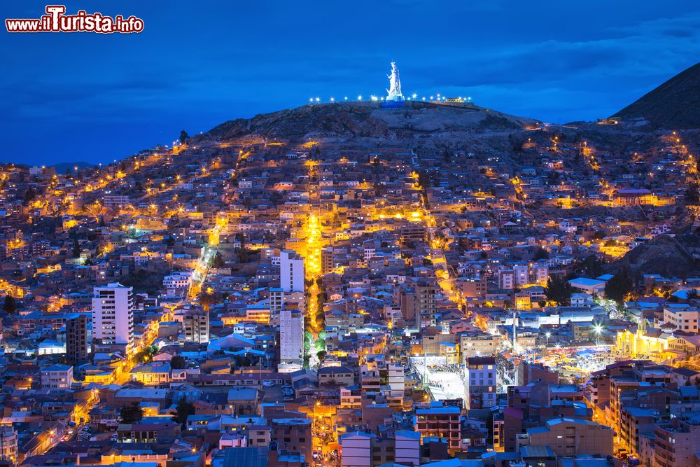 Immagine Una pittoresca veduta dall'alto by night di Oruro, Bolivia, con la statua della Madonna del Socavon sullo sfondo.