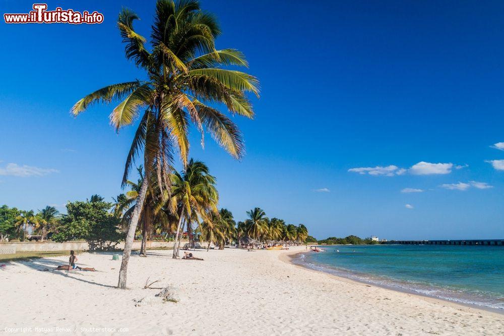 Immagine Turisti in relax a Playa Giron, Cuba. Palme, sabbia bianca e finissima e mare cristallino rendono questo scenario naturale meta prediletta per chi è alla ricerca di una vacanza all'insegna della tranquillità - © Matyas Rehak / Shutterstock.com