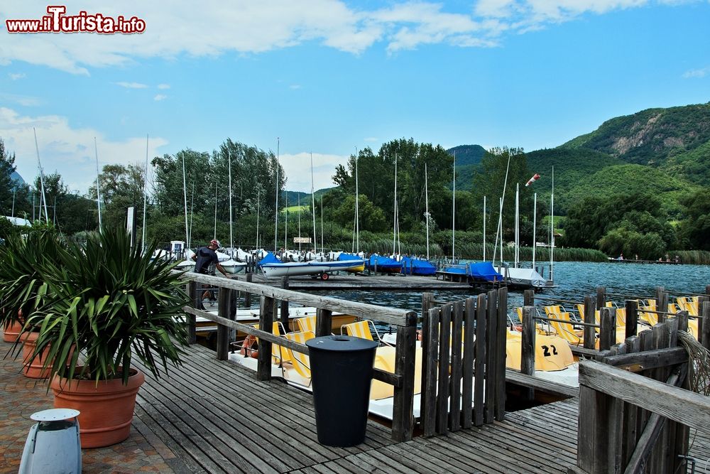 Immagine Il pontile da cui si accede al lago di Caldaro, Trentino Alto Adige. Molto frequentato dai turisti, il bacino lacustre ospita lungo le sue rive impianti balneari, piccoli e graziosi porti, campeggi e ristoranti.