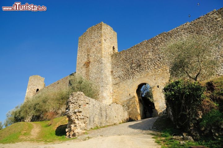 Immagine La porta di accesso alle mura di Monteriggioni (Toscana) - Tutto l'agglomerato del castello fu costruito nel 1200 e non di meno la sua porta. Questa aveva una duplice funzione: la prima sicuramente era quella di difesa, per contrastare i nemici fiorentini, la seconda era quella di estetica, in quanto la Repubblica di Siena ebbe da sempre avuto un gusto spiccato per il bello. Dal '500 in poi venne meno il motivo militare, poiché il ducato di Monteriggioni e quello di Firenze furono uniti. Da allora, rimase "solo" il secondo scopo: quello della meraviglia architettonica - © MauMar70 / Shutterstock.com