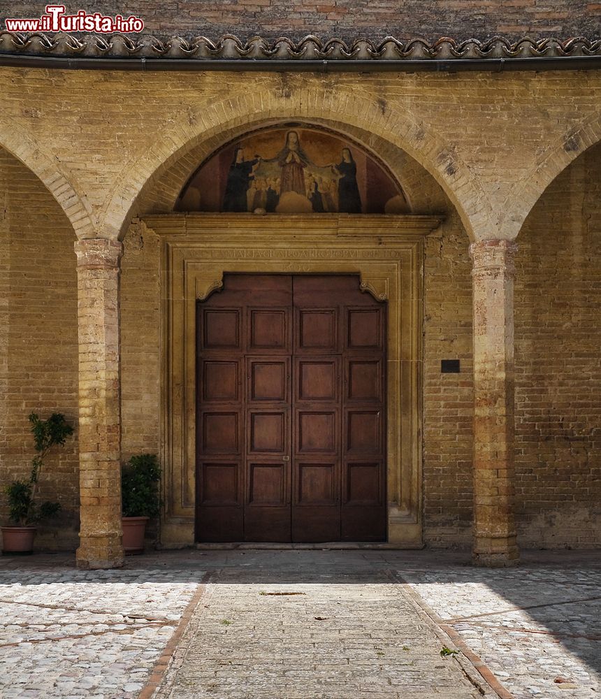 Immagine Il portale d'ingresso della chiesa di Santa Illuminata a Montefalco, Umbria. Fatto costruire dagli Agostiniani nel 1491, questo edificio religioso si presenta con una facciata rinascimentale in laterizio preceduta da un piccolo porticato che protegge il portale con architrave datato 1500.
