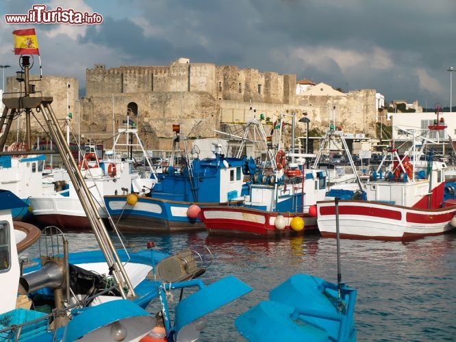 Immagine Porto dei pescatori e castello di Guzman a Tarifa, Spagna. Le tradizionali barche da pesca con la bella fortezza che si innalza nella parte più a sud della città - © Andreas Poertner / Shutterstock.com