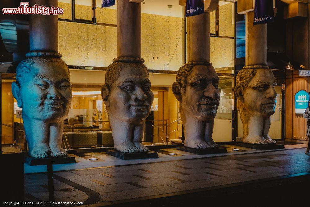 Immagine Quattro statue di volti lungo una strada di Osaka (Giappone) illuminate di notte - © FADZRUL NAZIEF / Shutterstock.com