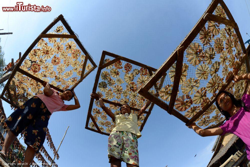 Immagine Ragazzini trasportano pesce essiccato all'aperto nella città di Myeik, sud del Myanmar - © amnat30 / Shutterstock.com