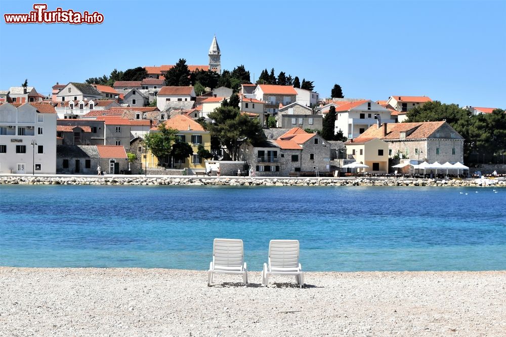 Immagine Relax su una spiaggia dell'antica Primosten, Croazia: due sdraio di fronte al sole.