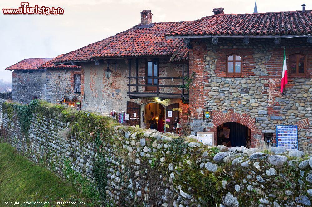 Immagine Ricetto di Candelo, Biella, durante il periodo di Natale, Piemonte. Durante l'Avvento le graziose vie del paese, fatte di ciottoli inclinati, si addobbano a festa e ospitano bancarelle e stand con prodotti artigianali - © Steve Sidepiece / Shutterstock.com