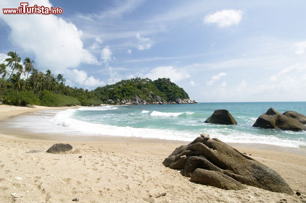 Immagine Rocce su una spiaggia di Ko Pha Ngan, Thailandia. Pur essendo molto popolare quest'isola a sud-est della Thailandia conserva ancora intatto il suo fascino più autentico. La coltivazione della noce di cocco continua a essere fonte di reddito per la popolazione locale.