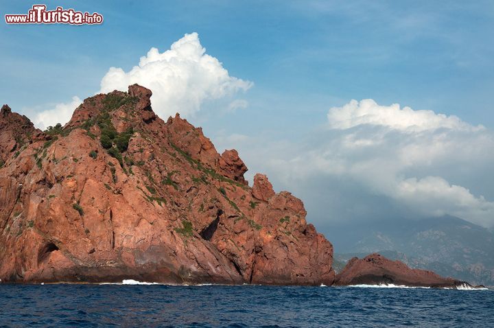 Immagine Paesaggio del litorale di Scandola, Corsica - come possiamo osservare in questa splendida foto, le rosse rocce vulcaniche della Riserva Naturale di Scandola sono uno dei principali elementi di fascino e bellezza naturali del luogo. A causa della loro composizione e del lento ma inesorabile processo di erosione dovuto all'acqua del mare, queste bellissime rocce sembrano quasi mostri marini mentre si ergono a formare elementi paesaggistici da cartolina: dalle gole, alle faglie, alle calette inaspettate e del tutto incontaminate. 