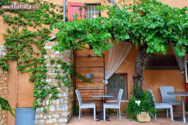 Immagine Bar e botteghe si susseguono lungo le strade tra gli edifici color ocra del borgo medievale di Roussillon, nella Francia meridionale -  © Oleg Znamenskiy / Shutterstock.com