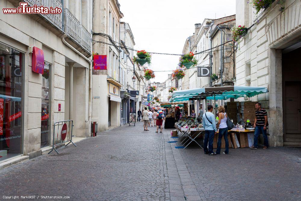 Immagine Rue d'Angouleme nel centro di Cognac: bancarelle di un mercatino all'aperto con gente a passeggio (Francia) - © MarkUK97 / Shutterstock.com