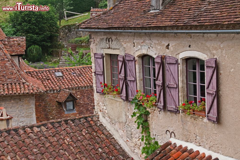Immagine Saint-Cirq-Lapopie (Francia): una graziosa casa in pietra con fiori alle finestre e persiane in legno, Occitania.
