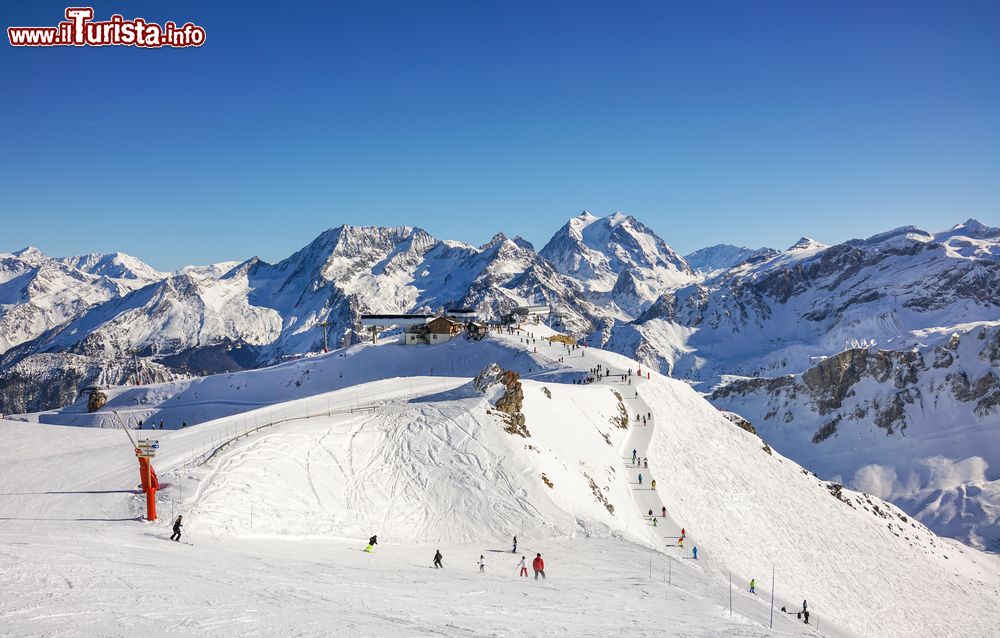 Immagine Sciatori e snowboarders nella stazione sciistica di Courchevel, Francia, in una bella giornata invernale di sole.