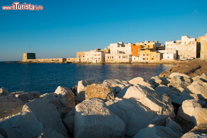 Immagine Scogli e case del centro storico di Trapani, Sicilia - Le caratteristiche abitazioni di Trapani che si affacciano sulle acque del Mediterraneo: circondata dal mare e protetta dal monte Erice, la città siciliana è una delle più interessanti dell'isola © Elisa Locci / Shutterstock.com