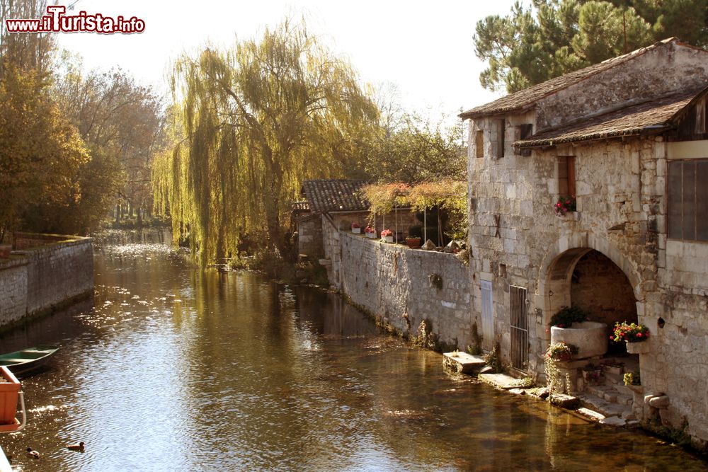 Immagine Scorcio bucolico del villaggio di Pons, Francia, con le vecchie case affacciate sul fiume.
