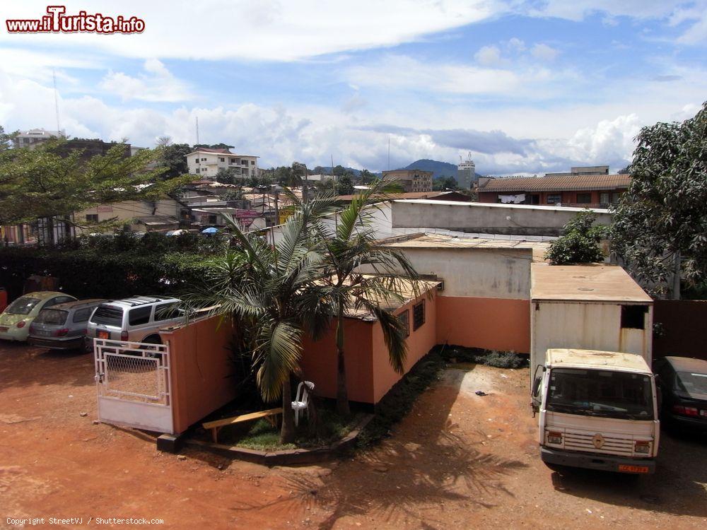 Immagine Scorcio di un cortile nel cuore di Yaoundé, Camerun, con auto e pulmini parcheggiati - © StreetVJ / Shutterstock.com