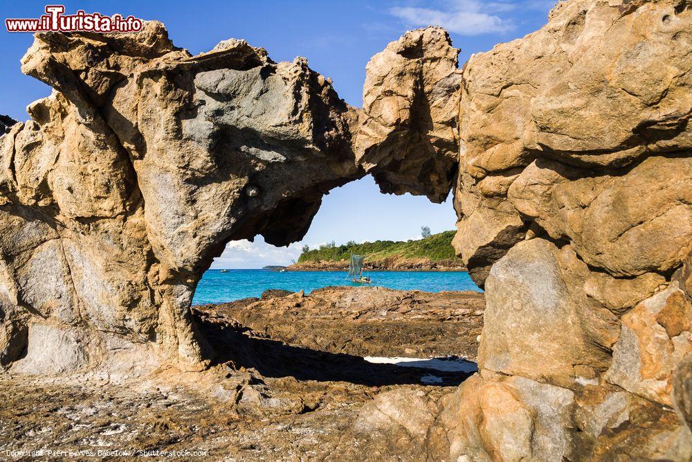 Immagine Scorcio di un'insenatura nell'isola di Tsarabanjina nei pressi di Nosy Be, Madagascar. Sullo sfondo, una tradizionale barca da pesca - © Pierre-Yves Babelon / Shutterstock.com