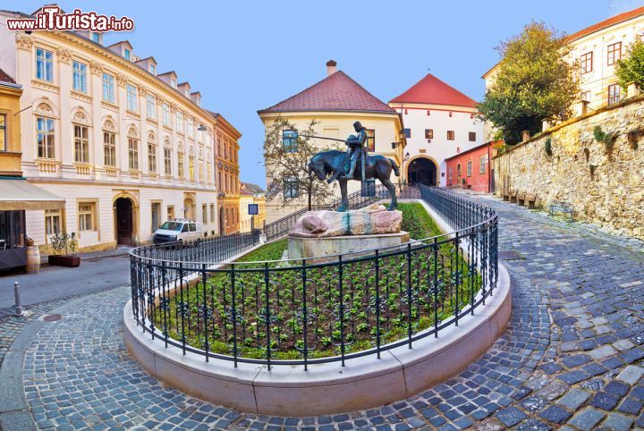 Immagine Scorcio panoramico del centro di Zagabria, Croazia. Una delle vie storiche della capitale: sullo sfondo un arco d'ingresso in pietra e, in primo piano, un monumento equestre - © xbrchx / Shutterstock.com