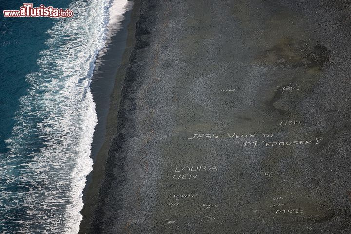 Immagine Utilizzando dei sassi bianchi, locali e turisti lasciano delle scritte sulla spiaggia nera di Nonza, che sono visibili dai punti panoramici sopra la spiaggia della Corsica