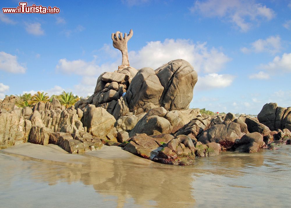 Immagine Scultura di sabbia a forma di mano su una spiaggia di Puerto Escondido, Messico.