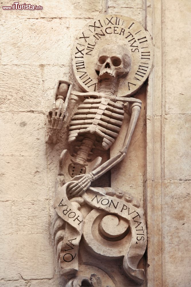 Immagine Scultura di uno scheletro nella chiesa del Purgatorio (1747) a Bitonto, Puglia. Le lesene e il timpano del portale, come volevano le regole della Controriforma, sono ornate da figure scheletriche e anime penitenti.