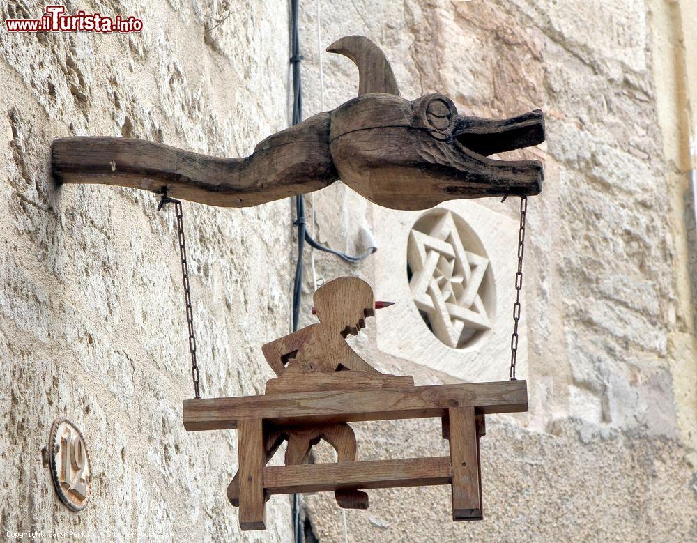 Immagine Scultura in legno come insegna di una falegnameria a Pezenas, Francia. Sullo sfondo, una stella di David scolpita nel muro. Siamo nel quartiere ebraico della cittadina - © Gary Perkin / Shutterstock.com