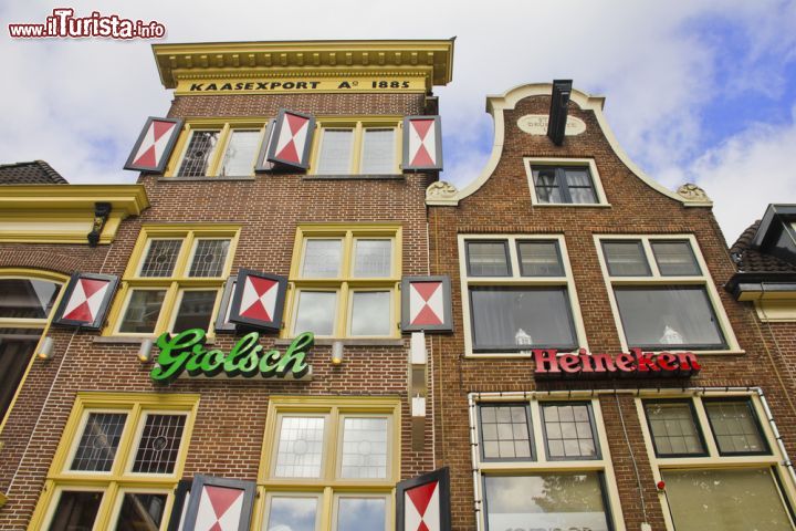 Immagine Un edificio tipico di Alkmaar in Olanda (Paesi Bassi) - In Irlanda gli edifici sono colorati, in Francia sono larghi e tendenzialmente isolati, in Spagna sono bassi e tutti vicini mentre in Olanda, sono sviluppatissimi in altezza. La loro maestosità porta lo spettatore a guardare in alto, quasi come se volesse cercare qualcosa. La tendenza ad Alkmaar, come si vede dall'immagine infatti, non è tanto quella di usare i tendoni ma quella di porre delle scritte sugli stessi edifici - © Giancarlo Liguori / Shutterstock.com