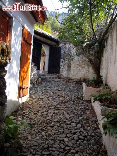 Immagine Una stradina di pietre a Blagaj, in Bosnia-Erzegovina - Blagaj è un pittoresco villaggio della Bosnia-Erzegovina, situato nei pressi di Mostar, nel sud della nazione. Questa caratteristica località e famosa in Bosnia, e non solo, per la sua incredibile posizione. Le case sono infatti costruita sul fianco di una parete rocciosa, affianco alla sorgente del fiume Buna e, a dominare il tutto, vi è l'imponente monastero islamico chiamato "Blagaj Tekija".- © DyziO / Shutterstock.com