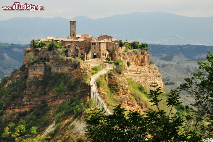 Immagine Il borgo di Civita di Bagnoregio, Lazio. Chi vuole ammirare il più suggestivo panorama sulla Valle dei Calanchi puo cercare una casa medievale che si trova quasi alla fine dell'abitato di Civita da dove accedere al terrazzino "Belvedere di Peppone". Con una piccola offerta al proprietario si può osservare il paesaggio circostante il borgo in tutto il suo splendore - © Studio Grafico Epics / Shutterstock.com