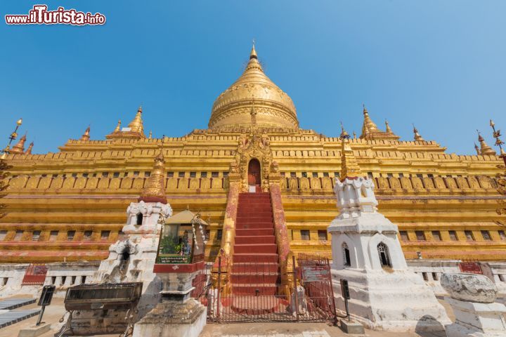Immagine Shwezigon Pagoda a Bagan, Myanmar. Interamente rivestito in oro, questo bel tempio sorge su una grande terrazza quadrata al centro della quale si innalza lo stupa circondato da altri edifici religiosi. Come ogni altro stupa, conserva le reliquie del Buddha: nello specifico, un osso della fronte e la copia di un dente. Fu costruita dal re Anawrata fra il 1044 e il 1077 - © TopKatai / Shutterstock.com