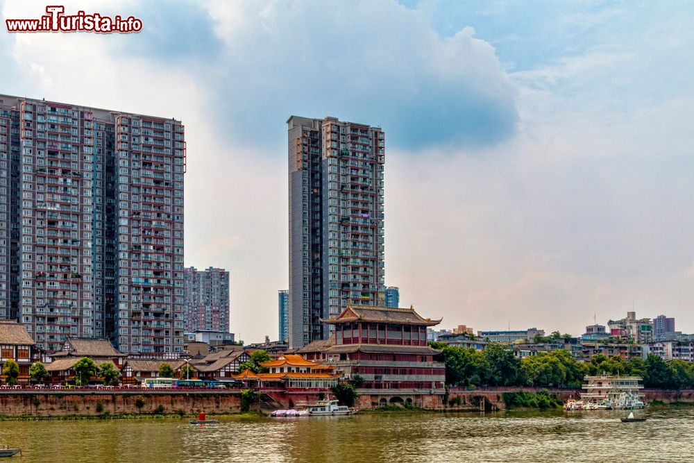 Immagine Skyline di Leshan affacciata sul fiume, Cina. Un pittoresco contrasto fra gli edifici di antica costruzione e quelli di epoca moderna con torri e grattacieli.