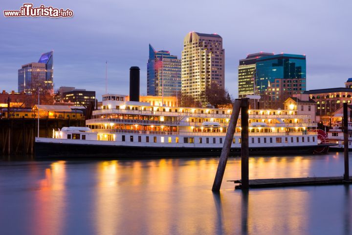 Immagine Skyline notturno di Sacramento, California - Capoluogo della contea di Sacramento e capitale dello stato della California, questa città statunitense fu fondata nel 1848 da John Sutter Jr. Situata alla confluenza dei fiumi Sacramento e American, ha una superficie di circa 250 chilometri quadrati: centro ferroviario, manifatturiero e commerciale della valle, dove vengono prodotti frutta, riso e farina, è anche un importante centro di allevamento del bestiame. Interessante di giorno, la città è ancora più suggestiva al tramonto quando il calar del sole disegna sull'acqua del fiume l'incantevole skyline © Andrew Zarivny / Shutterstock.com