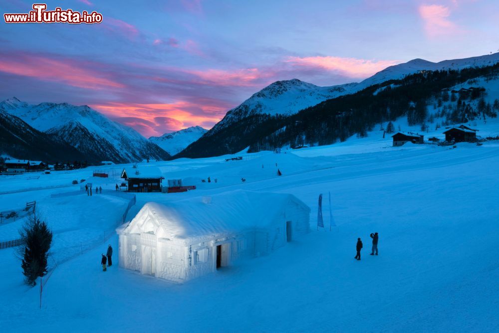 Immagine Snow Dream Experience proposta da Lungolivigno: un grande chalet di neve, sul pendio davanti all’Hotel Lac Salin SPA & Mountain Resort e alla sua Mandira SPA, dalla grande piscina panoramica sulle vette innevate.