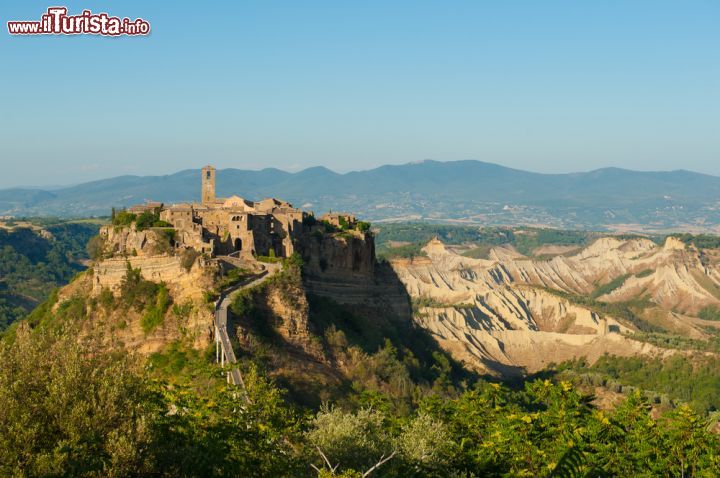 Immagine Lo sperone di tufo su cui sorge Civita di Bagnoregio, Lazio. Fondata 2500 anni fa dagli etruschi, Civita si innalza su una delle più antiche vie d'Italia, quella che congiunge il Tevere, un tempo grande via di navigazione, al lago di Bolsena. Purtroppo già all'epoca etrusca fu necessario far fronte a grandi problemi di sismicità e instabilità dell'area poiché nel 280 a.C. si verificarono scosse telluriche e smottamenti. Quando in questo territorio arrivarono i romani, alcuni decenni più tardi, vennero riprese e completate le opere di canalizzazione delle acque e di contenimento dei torrenti già avviate precedentemente dagli etruschi - © Sam Strickler / Shutterstock.com