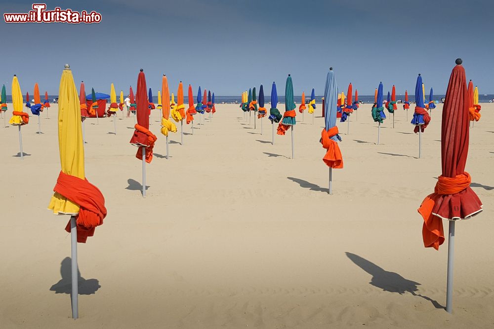 Immagine Spiaggia con ombrelloni chiusi a Deauville, Normandia (Francia). Quella di Deauville è una delle più belle spiagge della Normandia e i suoi ombrelloni colorati, fotografati da turisti di tutto il mondo, ne sono diventato il principale simbolo.