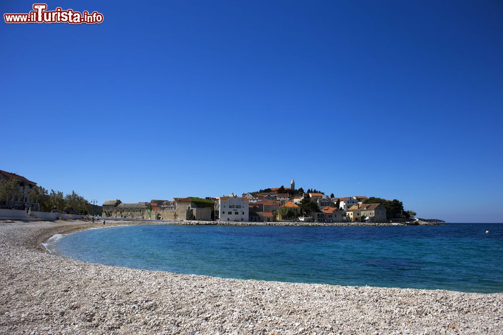 Immagine Spiaggia di ciottoli lungo la costa della città di Primosten, Croazia. L'acqua dell'Adriatico lambisce questa pittoresca località della Dalmazia.