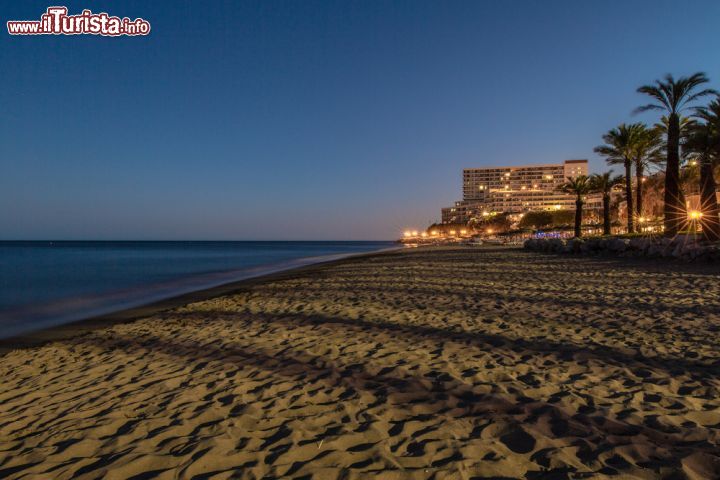 Immagine Spiaggia di sera a Torremolinos, Spagna. Le luci dei palazzi e delle strutture che si affacciano sul mare illuminano questo tratto di litorale sabbioso creando un'atmosfera ancora più suggestiva - © Bildagentur Zoonar GmbH / Shutterstock.com