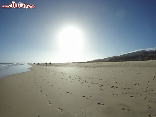 Immagine Cielo diurno e distesa di sabbia della spiaggia Morro Jable, Fuerteventura (Spagna) - Quest'immagine mostra un cielo terso e il sole splendente della spiaggia di Morro Jable. La sabbia è così bianca e fine che i passi di ogni passante rimangono registrati su di essa come se fosse il pennello su una tela. Lunghissime camminate e passeggiate in relax qui sono all'ordine del giorno, un'oasi perfetta per i momenti romantici più belli.