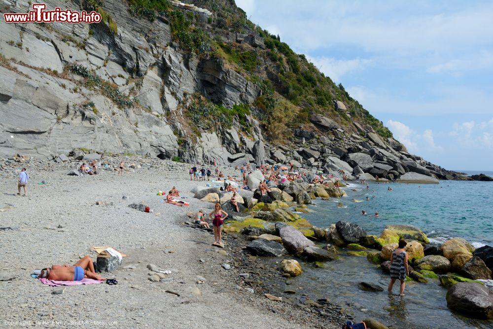 Immagine Turisti sulla spiaggia rocciosa di Vernazza, La Spezia, Liguria.  Il paese è incastonato in una baia fra i Comuni di Monterosso al Mare e Riomaggiore - © JanHetman / Shutterstock.com