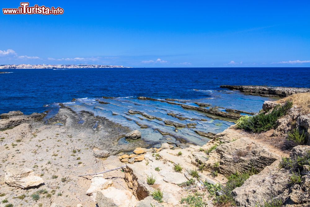 Immagine Spiaggia siciliana nella Riserva Naturale del Plemmirio a Siracusa. Questo tratto di costa sud -orientale della regione ospita una delle aree marine protette più belle d'Italia con insenature rocciose, calette, scogliere calcaree e un mare limpido e trasparente.