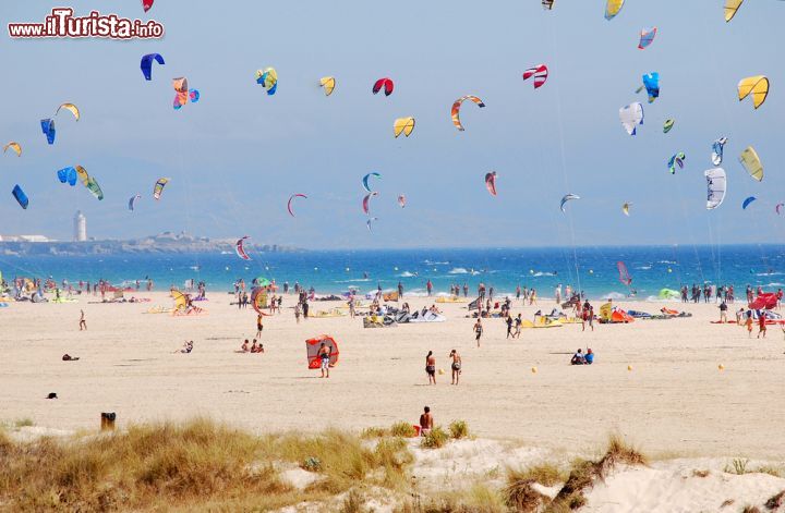 Immagine Sulla spiaggia di Tarifa con il kitesurf, Spagna. Aquiloni colorati su questo tratto di costa litoranea dell'Andalusia, da sempre zona frequentata dagli apapssionati di questo sport per via della presenza del vento - © Stewie74 / Shutterstock.com